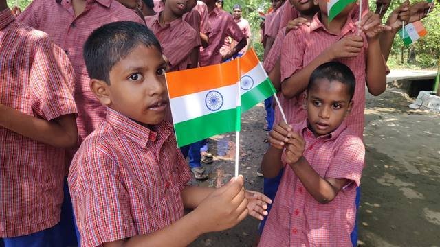 A smiling boy holding the national flag